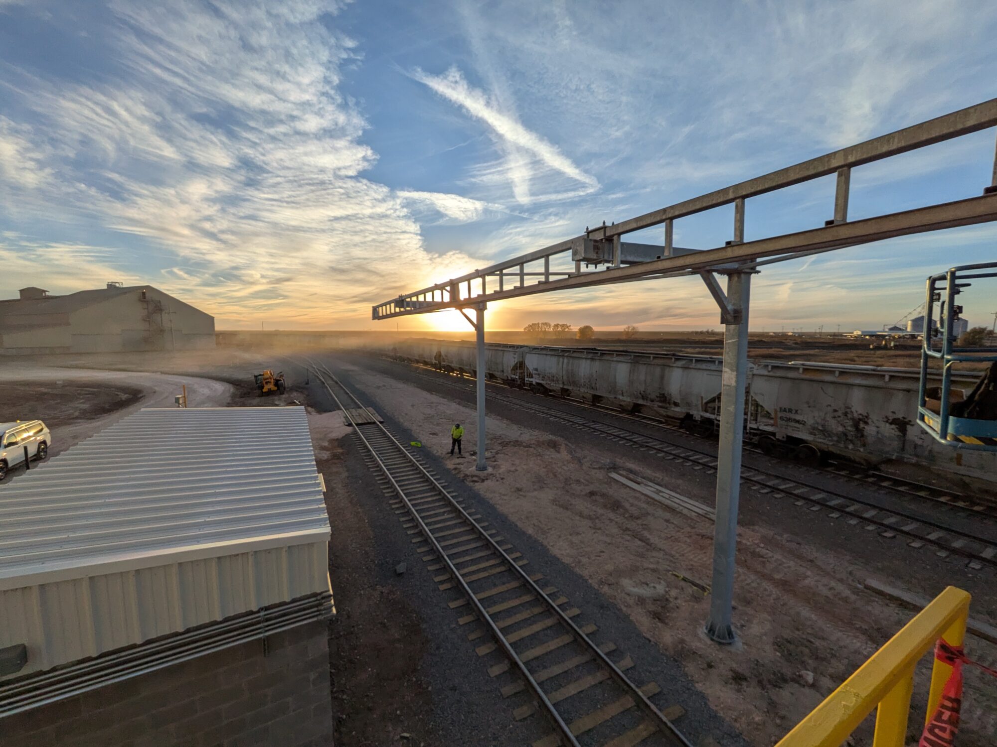 overhead fall protection multi-column rail, outdoors with railroad tracks and farm