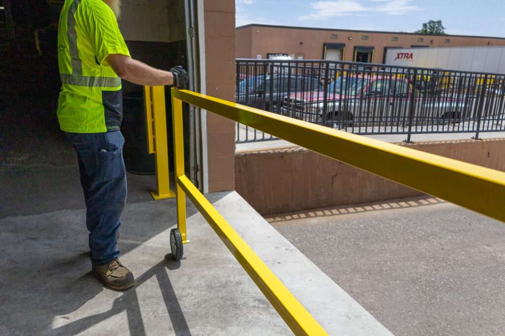 Warehouse worker opening roller gate at loading dock