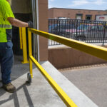 Warehouse worker opening roller gate at loading dock